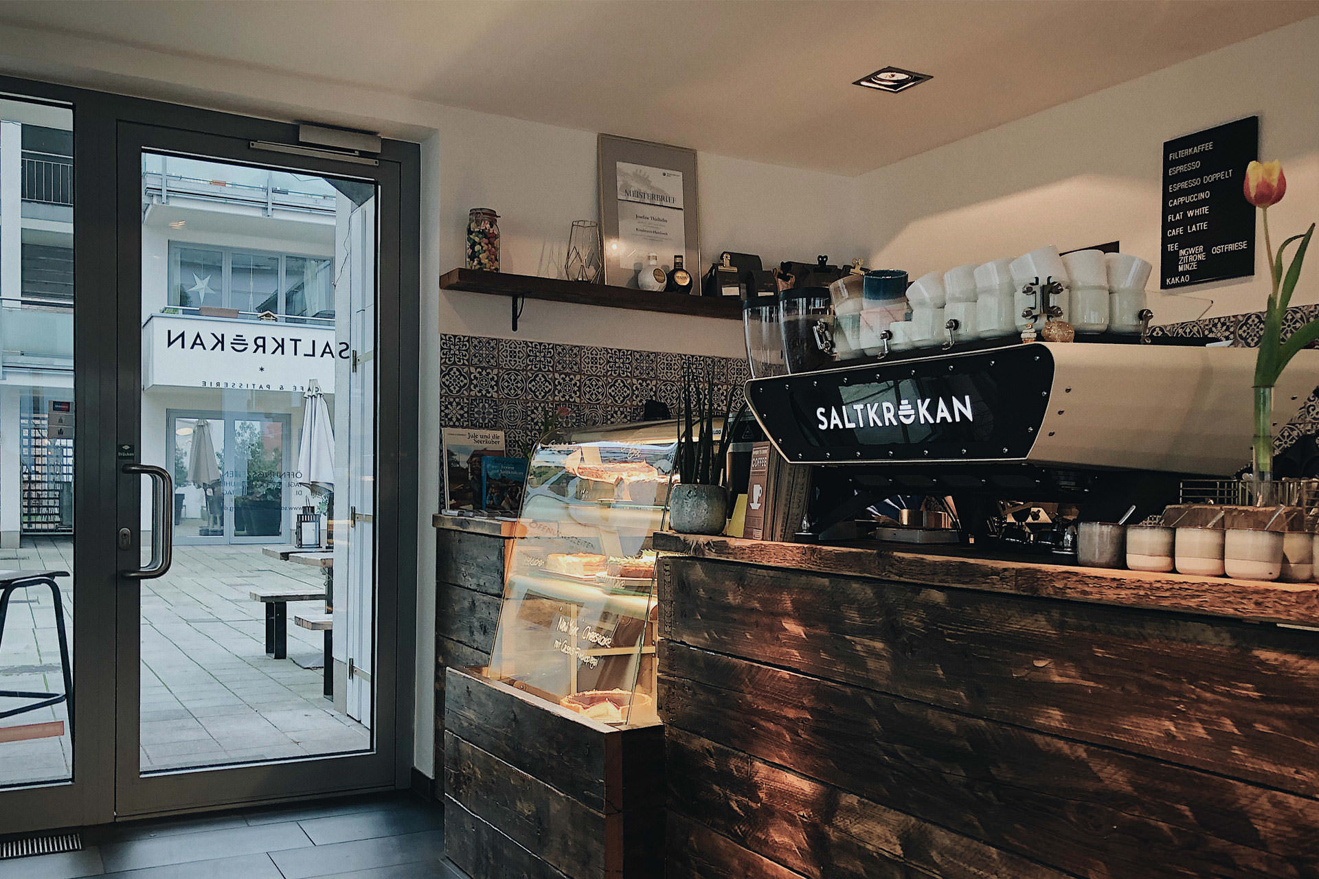 Kaffeebar mit Espressomaschine und Kuchenvitrine